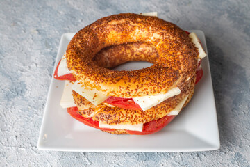 Traditional Turkish breakfast with Turkish bagel with cheese and tomatoes (Turkish name; simit or gevrek)