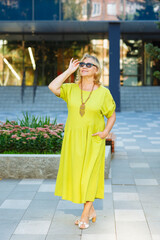 Fototapeta premium an elderly woman in a green dress in the park