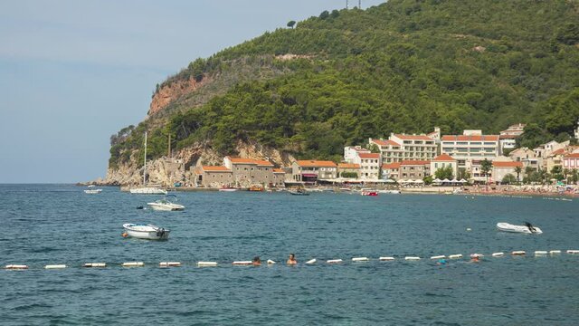 Relaxation on beach, seaside resort with people and boats moving time lapse video. Petrovac Montenegro.