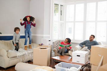 Obraz premium Family taking a break from moving, relaxing in living room