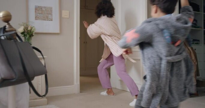 funny little boy chasing mother with toy gun blowing bubbles running through house playing catch mom enjoying fun game with son enjoying weekend morning together 4k footage
