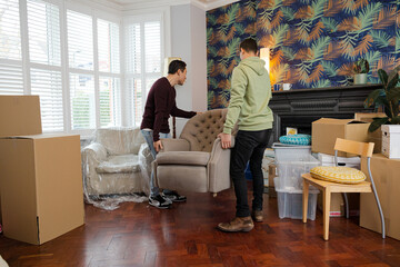 Fototapeta premium Men carrying armchair in living room