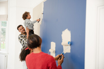 Happy family painting wall
