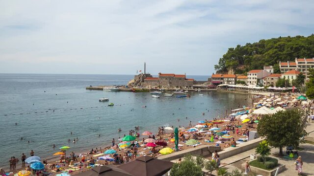 Relaxation on beach, seaside resort with people and boats moving time lapse video. Petrovac Montenegro.