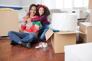 Portrait mother and daughter hugging in living room