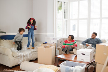 Obraz premium Family taking a break from moving, relaxing in living room