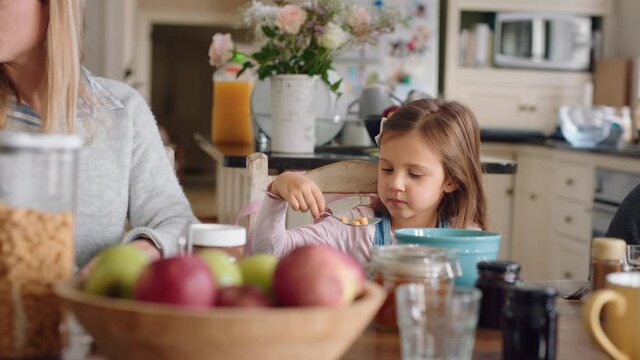 happy family eating breakfast together parents preparing cereal for children in kitchen at home