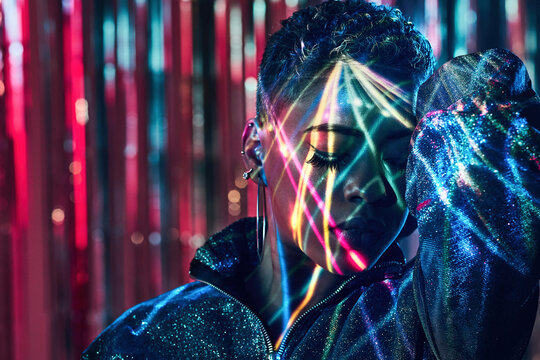 Cool black model in ultraviolet light dancing in nightclub
