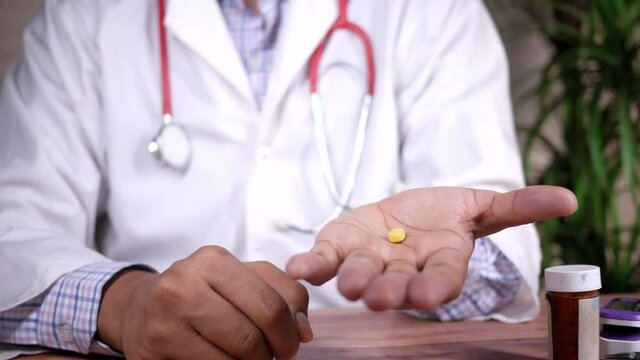 doctor holding medical pill on palm of hand 