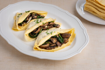 savoury stuffed mushroom spinach crepe on oval plate