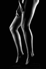 female legs in high heels shoes. girl silhouette in the dark