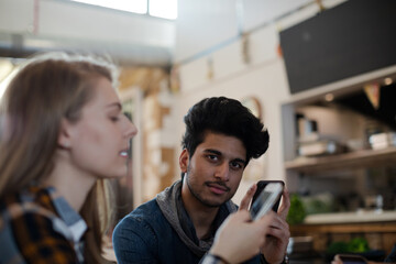 Young adults using smart phones at table