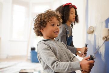 Happy children painting wall