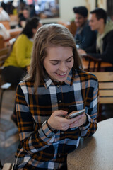 Smiling, happy teenage girl using smart phone