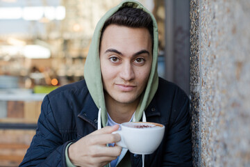 Portrait of teenage boy drinking coffee