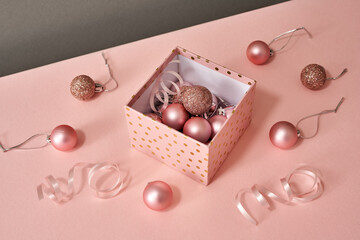 A box with Christmas or New Year ornaments on pink background