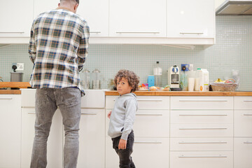 Father and son standing in kitchen