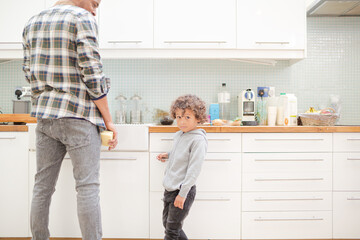 Father and son standing in kitchen