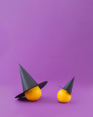 Big and small pumpkin squashes wearing witch hats. Fun minimal Halloween card idea with copy space.