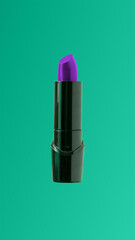 Purple lipstick in blank black tube on green background. Fun Halloween, punk and goth style