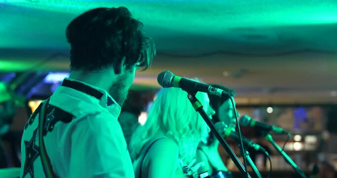Country singer performs in a basement bar.