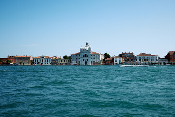 Fototapeta na wymiar Venetian gondolier punting gondola through green canal waters of Venice Italy 