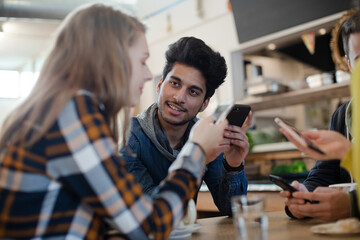 Young adults using smart phones at table