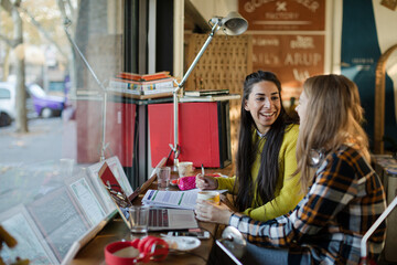 Young female college students studying in cafe