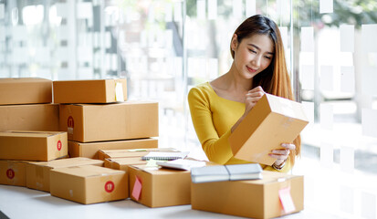 Portrait of businesswoman start small business and successful SME entrepreneurs A female works from home delivering parcels online ideas SME delivery and packaging concept.