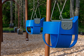 Empty playground with swings and baby seats - obrazy, fototapety, plakaty