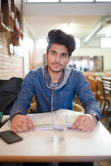 Fototapeta premium Focused young male college student studying in cafe