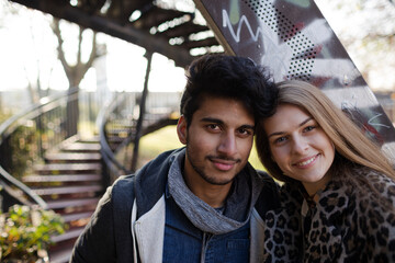 Portrait confident young couple next to urban stairs