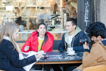 Young adult friends talking at sidewalk cafe