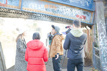 Young adults vlogging under urban bridge