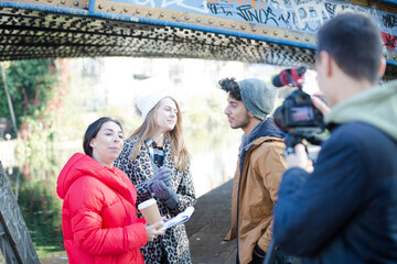 Young adults vlogging under urban bridge