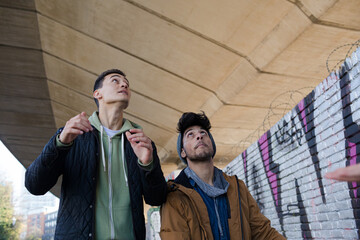 Two young men with soccer ball in urban tunnel