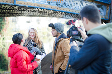 Young adults vlogging under urban bridge