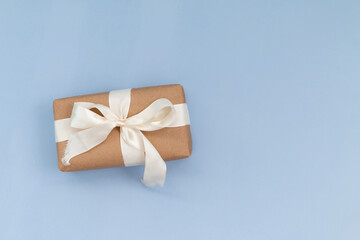 handmade gift box from paper craft with ribbon isolated on blue background