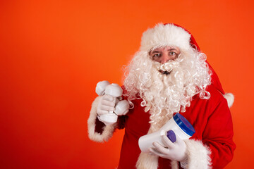 Cute toast santa claus with dumbbells in his hands on an orange background. Sports nutrition and exercise for weight loss.