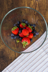strawberries and blueberries in a glass bowl