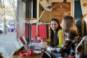 Young female college students studying in cafe