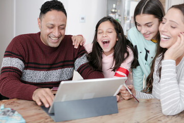 Family using digital tablet at kitchen table