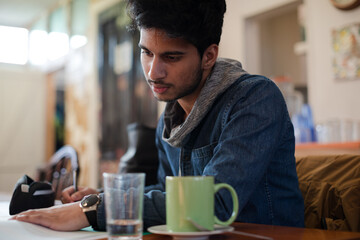 Portrait confident young male college student studying in cafe
