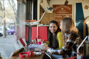 Young female college students studying in cafe
