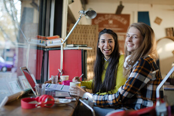 Young female college students studying in cafe
