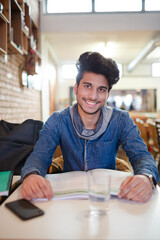 Fototapeta na wymiar Focused young male college student studying in cafe