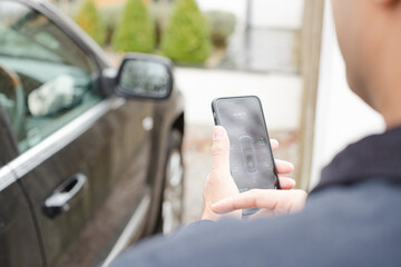 Personal perspective man setting car alarm from smart phone
