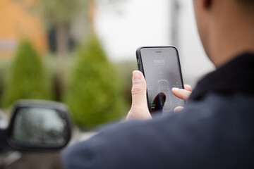 Personal perspective man setting car alarm from smart phone