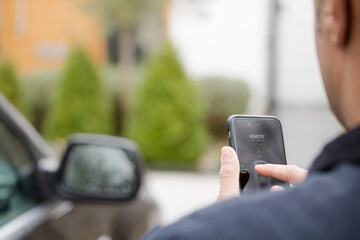 Personal perspective man setting car alarm from smart phone