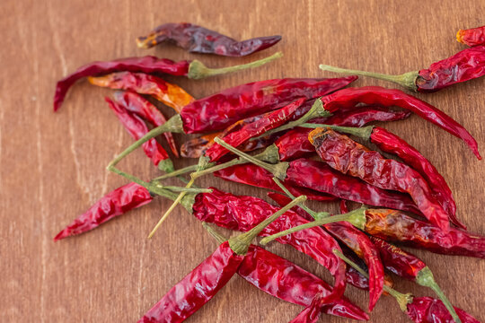 red chili pods of red chili peppers dried wooden background close up